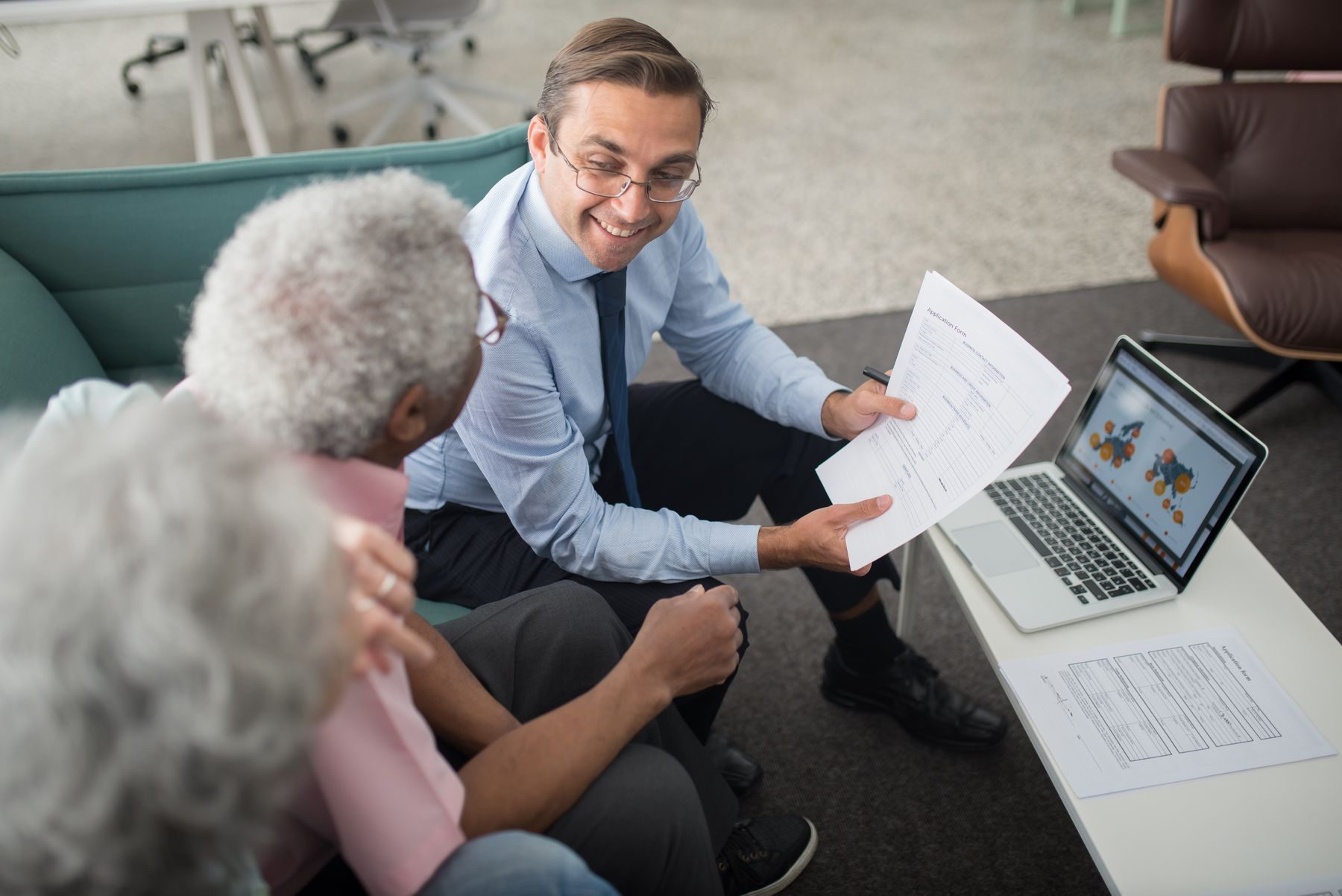 Funding advisor reviewing paperwork with a business owner at a desk